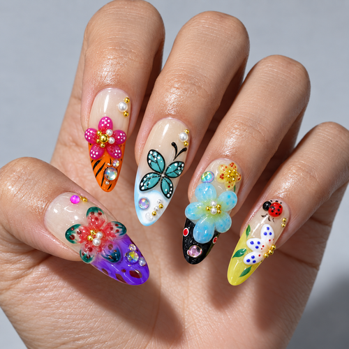 A close-up of a hand displaying five long, decorated almond-shaped nails with colorful floral, butterfly, and ladybug nail art designs.